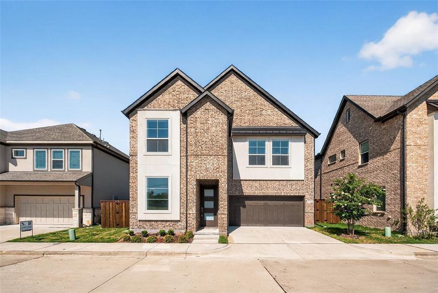 View of front of home featuring driveway, a garage, stucco siding, a gate, and brick siding