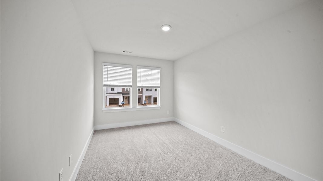Carpeted bedroom with large windows in two story townhome at Ransdell Pointe by DRB Homes in Spartanburg, SC Carpeted bedroom with large windows in two story townhome at Ransdell Pointe by DRB Homes in Spartanburg, SC