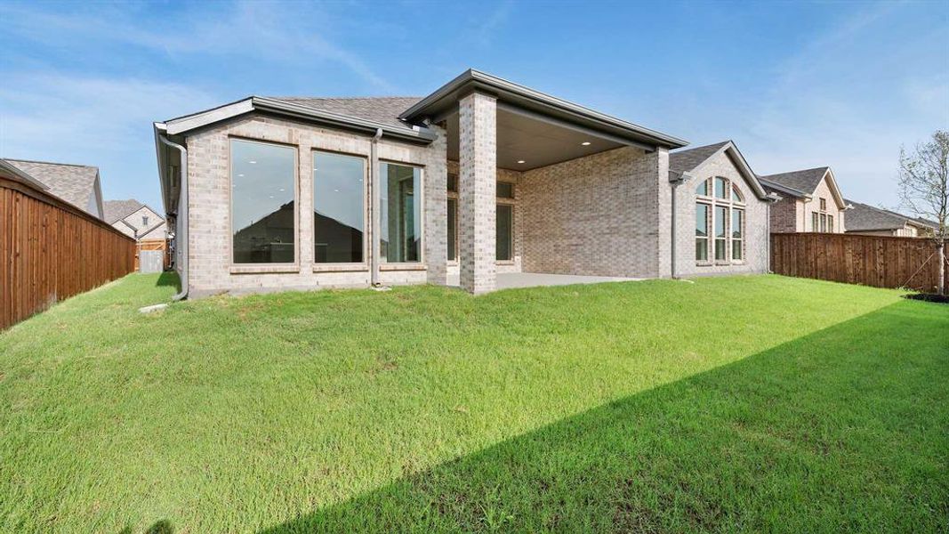 Rear view of property with a yard and a patio area