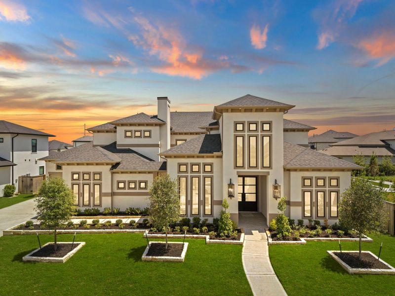 Striking front elevation captured at night, showcasing the home's elegant architecture and dramatic exterior lighting.