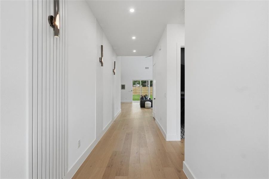 Hallway featuring light wood-finish flooring, recessed ceiling lighting, and clean white walls Hallway featuring light wood-finish flooring, recessed ceiling lighting, and clean white walls