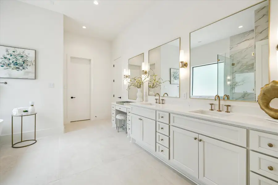 Primary bath - features quartz counter top,  double-sink and vanity, designer sconce lighting and porcelain flooring.