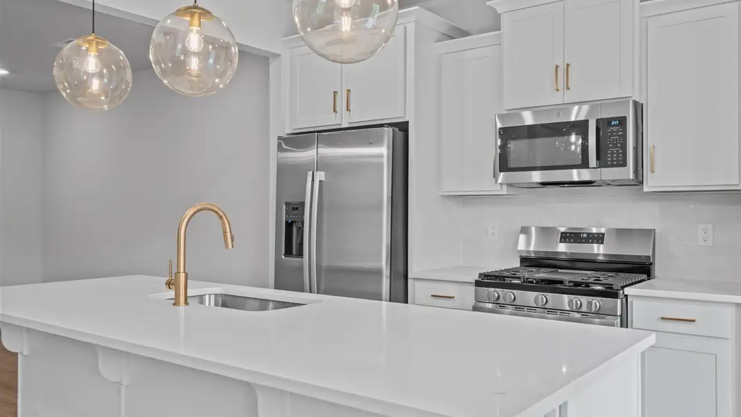 First-class kitchen with a spacious 9-foot island perfect for entertaining beneath designer pendant lighting First-class kitchen with a spacious 9-foot island perfect for entertaining beneath designer pendant lighting