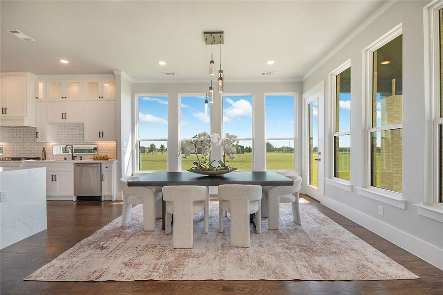 Dining area featuring plenty of natural light, ornamental molding, dark wood-type flooring, and recessed lighting Dining area featuring plenty of natural light, ornamental molding, dark wood-type flooring, and recessed lighting