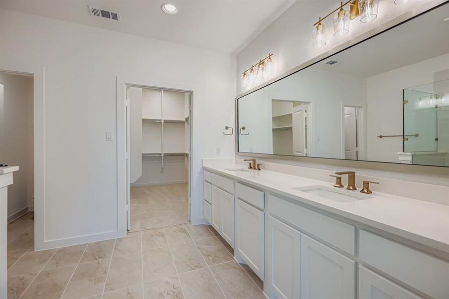 Full bath with double vanity, a stall shower, a spacious closet, recessed lighting, and light tile patterned floors Full bath with double vanity, a stall shower, a spacious closet, recessed lighting, and light tile patterned floors