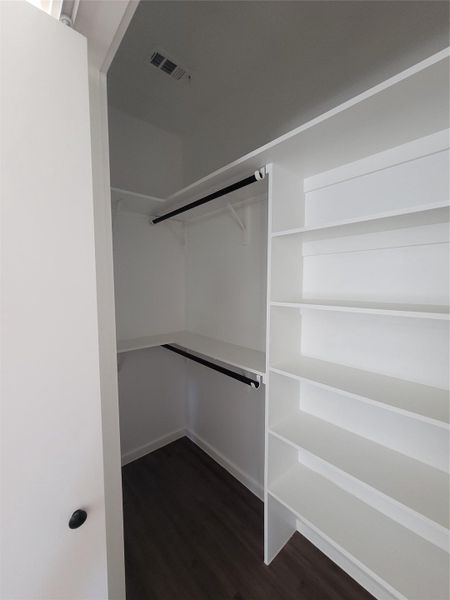 Ample shelving and hanging space in this well-organized walk-in closet.