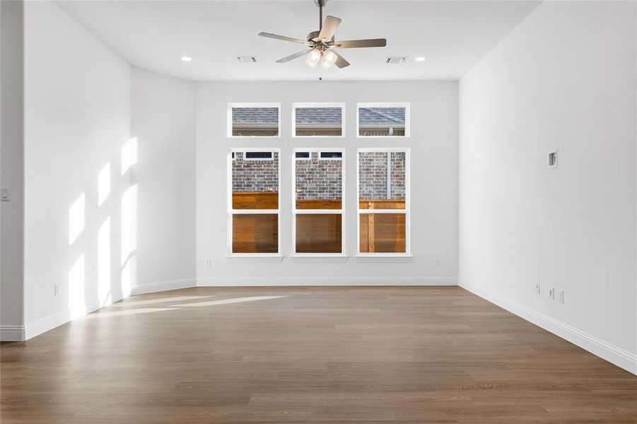 Spare room with wood finished floors, ceiling fan, and recessed lighting