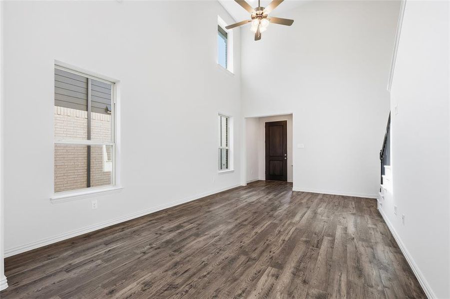 Spacious room featuring vaulted ceilings, wood-finish flooring, and multiple windows