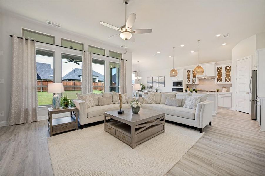 Bathed in natural light and thoughtfully designed for modern living, this expansive great room serves as the centerpiece of the home. Large picture windows showcase backyard views while the seamless connection to the kitchen and dining spaces creates an ideal environment for entertaining. As an added bonus, all living room furnishings convey with the home, offering exceptional value and turnkey convenience Bathed in natural light and thoughtfully designed for modern living, this expansive great room serves as the centerpiece of the home. Large picture windows showcase backyard views while the seamless connection to the kitchen and dining spaces creates an ideal environment for entertaining. As an added bonus, all living room furnishings convey with the home, offering exceptional value and turnkey convenience