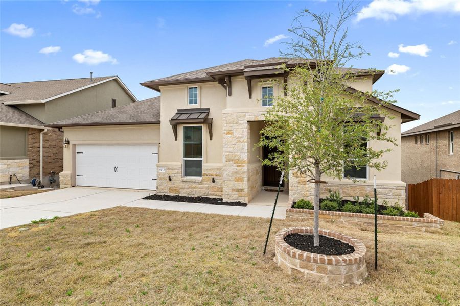 View of front facade with stucco siding, stone siding, a garage, concrete driveway, and a shingled roof