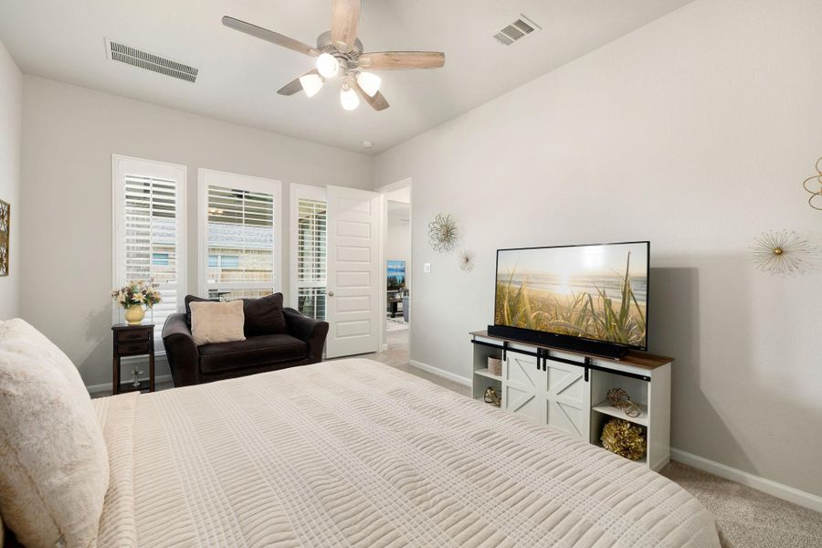 Spacious primary suite with shutters, abundant natural light, & relaxing atmosphere.