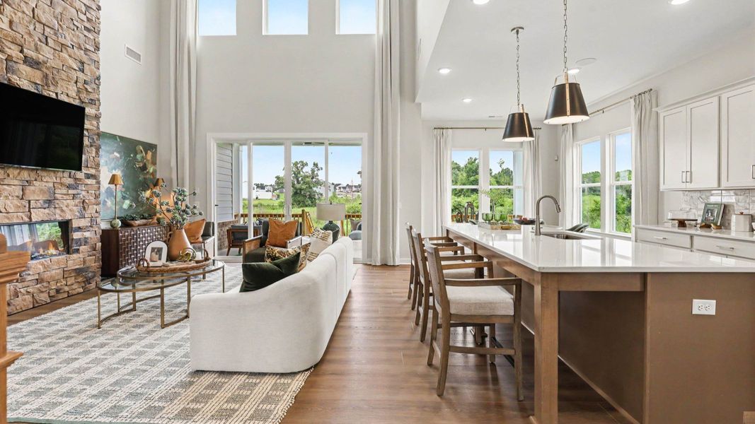 Gathering room with high ceilings and view of kitchen