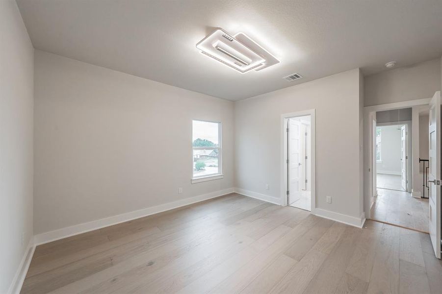 Unfurnished bedroom with light wood-style flooring and baseboards