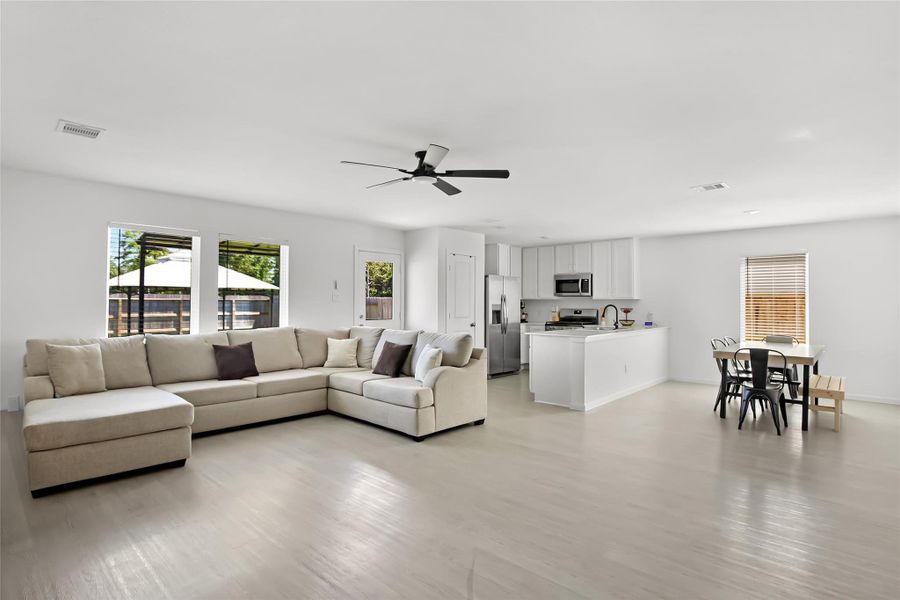 Family room, dining area and kitchen view. Light and bright sunlight in here and the walls are very neutral -- you could add a pop of color!