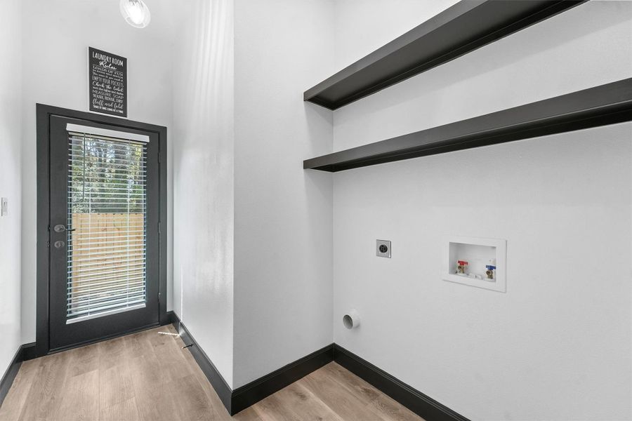 Enjoy a bright and roomy laundry area with convenient shelving and outdoor access.