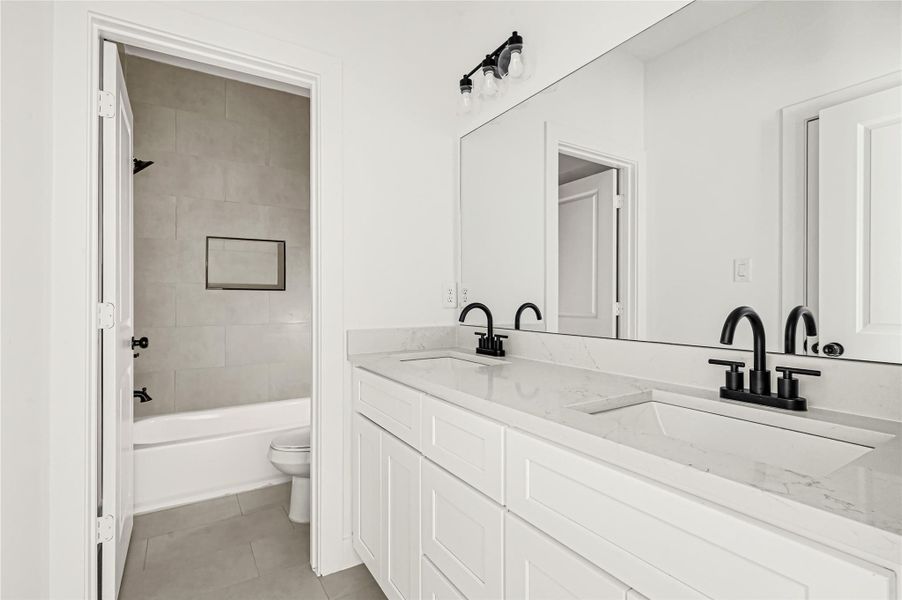 Spa-inspired bathroom featuring dual vanities and modern finishes. Spa-inspired bathroom featuring dual vanities and modern finishes.