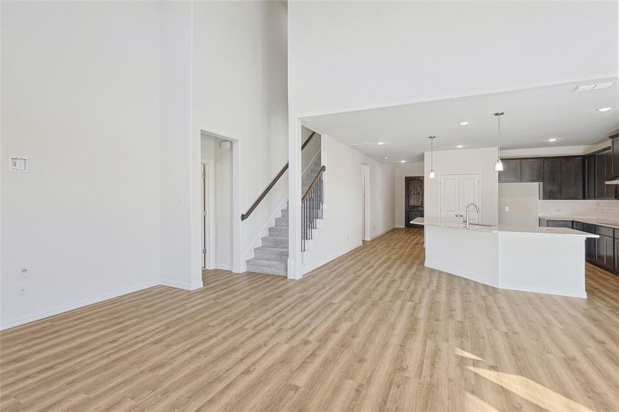 Unfurnished living room with sink and light hardwood / wood-style flooring