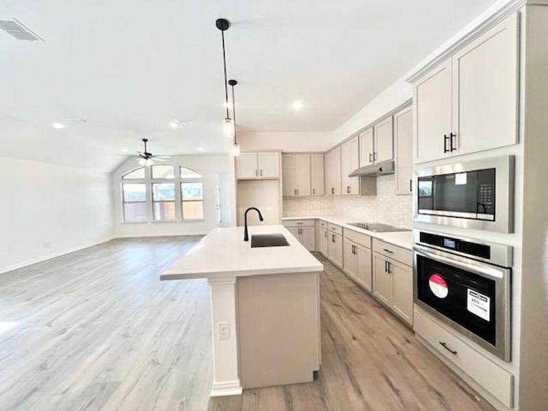 Kitchen with a sink, ceiling fan, under cabinet range hood, stainless steel oven, and built in microwave Kitchen with a sink, ceiling fan, under cabinet range hood, stainless steel oven, and built in microwave