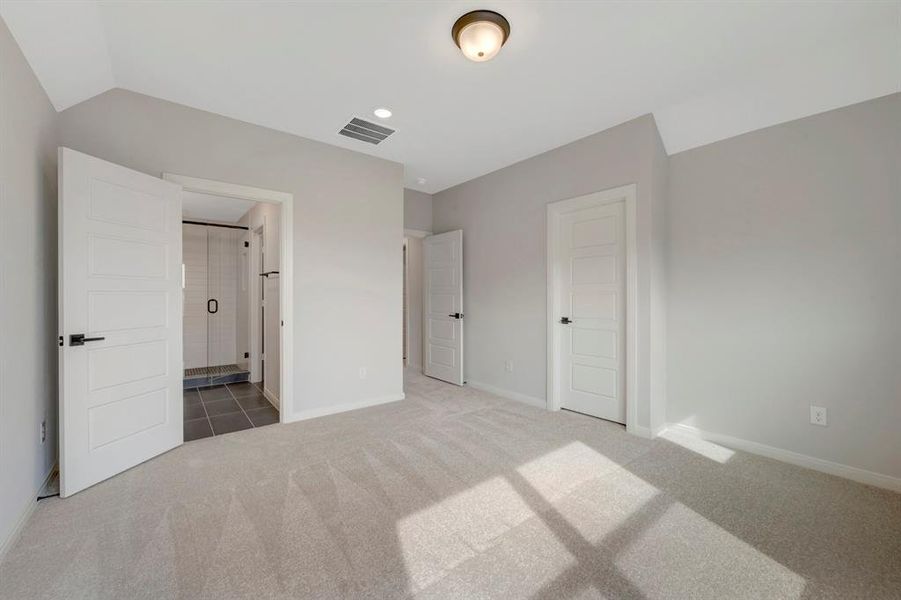 Unfurnished bedroom with carpet flooring, ensuite bath, recessed lighting, and lofted ceiling