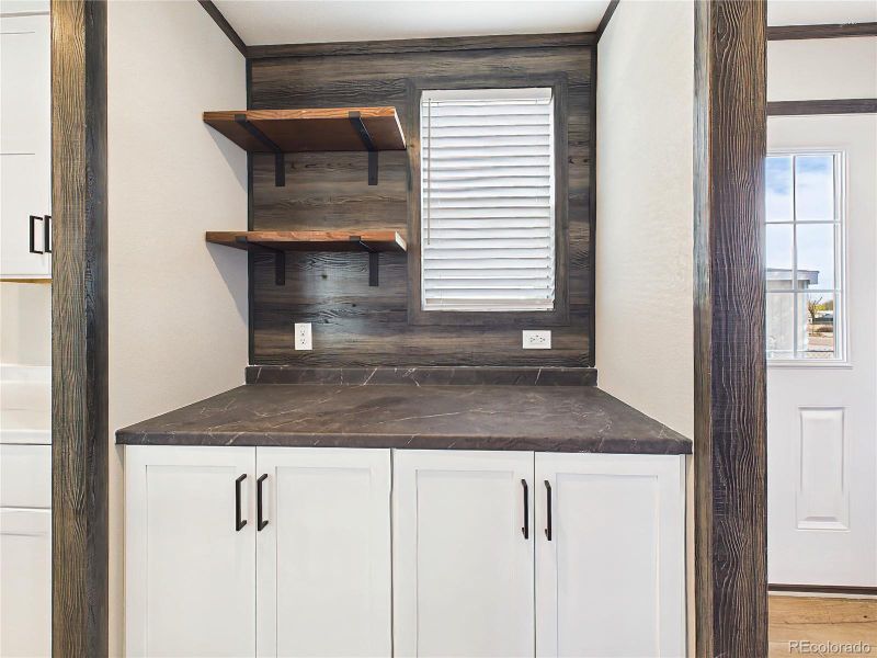 Coffee Bar / Prep Area – Dedicated prep or coffee station with built-in cabinetry, open shelving, and a convenient workspace for added functionality.