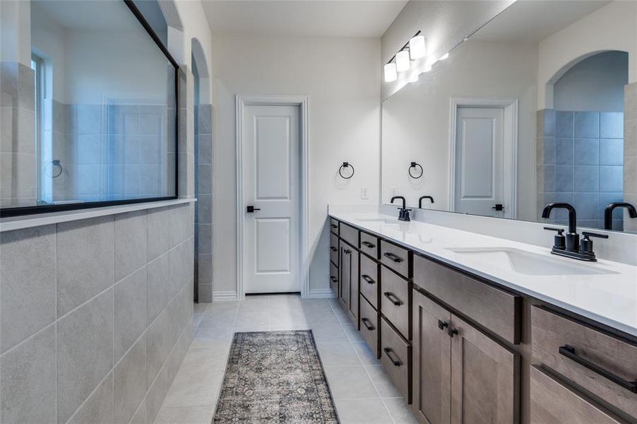 Bathroom featuring double vanity and light tile patterned floors
