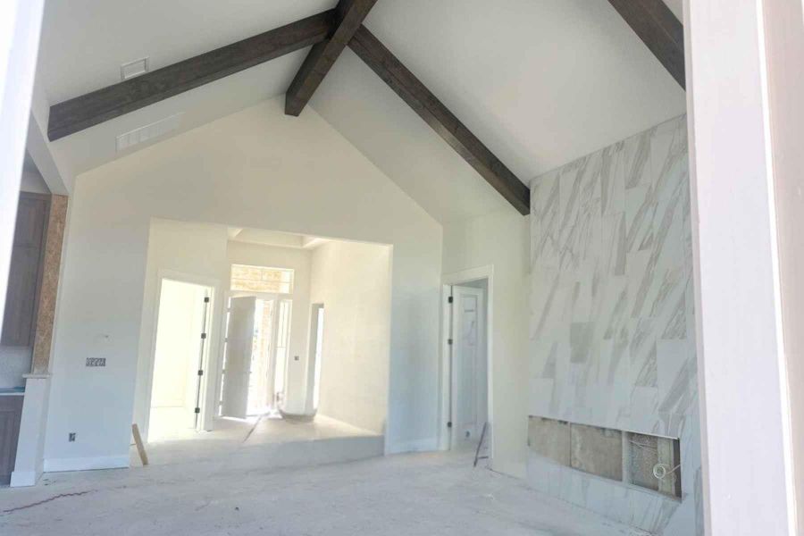 Empty room featuring high vaulted ceiling and beamed ceiling Empty room featuring high vaulted ceiling and beamed ceiling