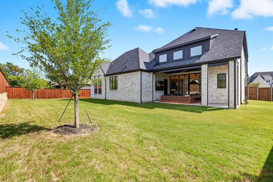 Rear view of property with a patio area, a fenced backyard, brick siding, and roof with shingles Rear view of property with a patio area, a fenced backyard, brick siding, and roof with shingles