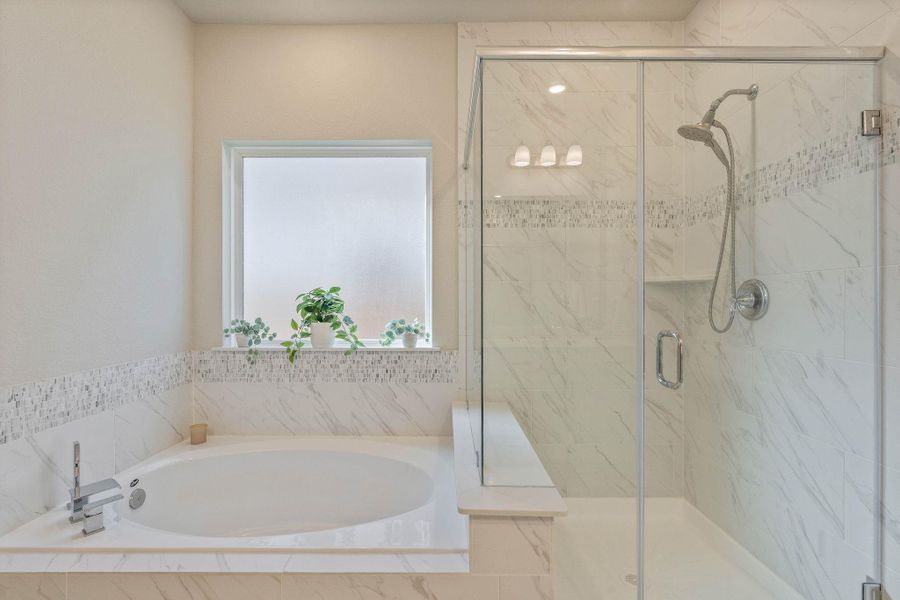 This bathroom features a modern design with a spacious glass-enclosed shower and a large bathtub. The neutral color palette is complemented by elegant tiles and a frosted window, adding natural light and privacy. This bathroom features a modern design with a spacious glass-enclosed shower and a large bathtub. The neutral color palette is complemented by elegant tiles and a frosted window, adding natural light and privacy.