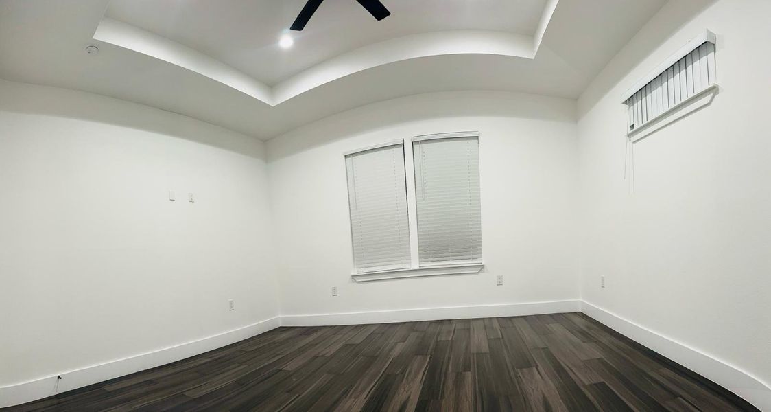 Empty room featuring dark wood-type flooring, a ceiling fan, and vaulted ceiling Empty room featuring dark wood-type flooring, a ceiling fan, and vaulted ceiling