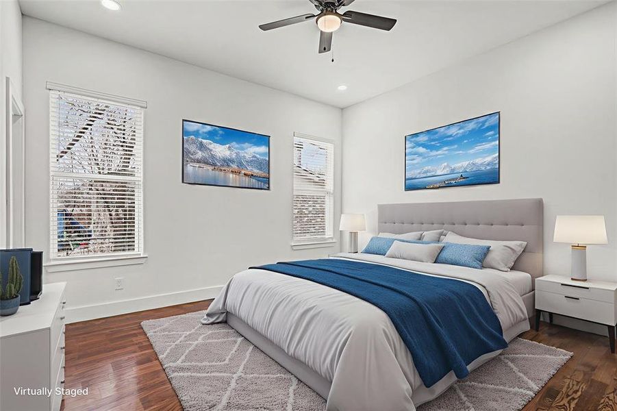 Bedroom with dark wood-type flooring, a ceiling fan, and recessed lighting - virtually staged