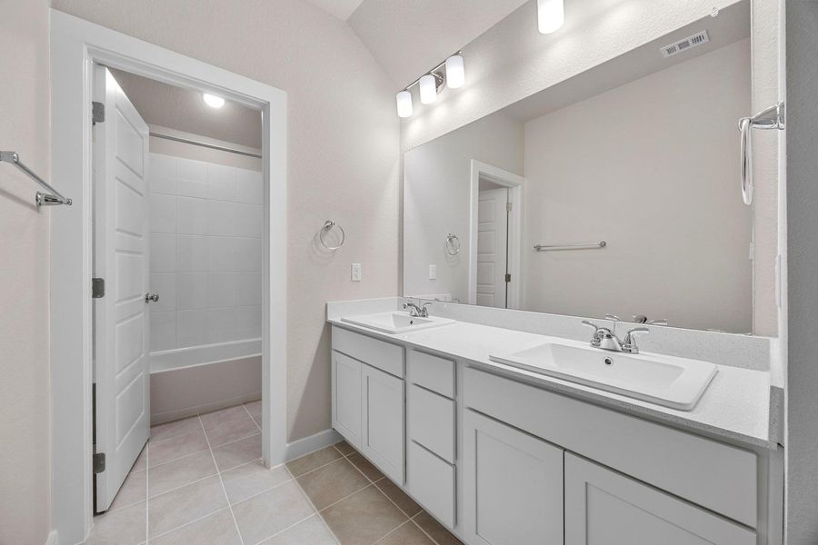 Double vanities with sleek countertops and ample storage enhance this well-appointed bathroom. Double vanities with sleek countertops and ample storage enhance this well-appointed bathroom.