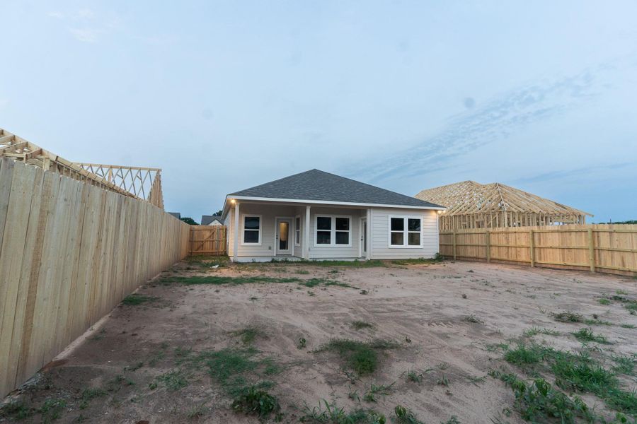 Rear view of house featuring a fenced backyard