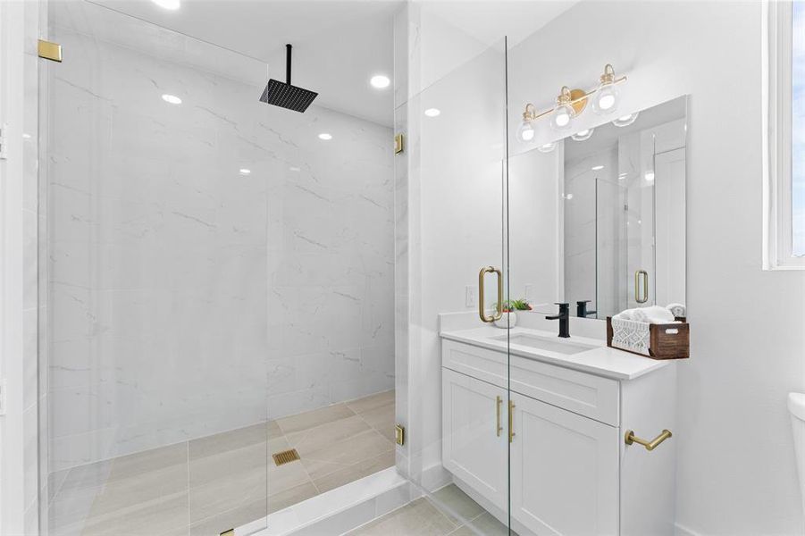 Full bath with a marble finish shower, vanity, and recessed lighting
