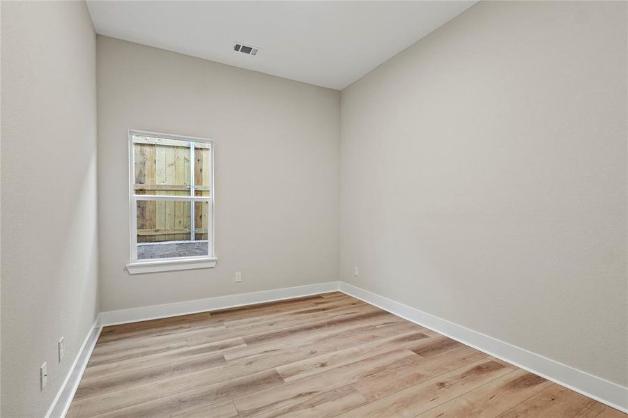 Unfurnished room featuring light wood finished floors and baseboards