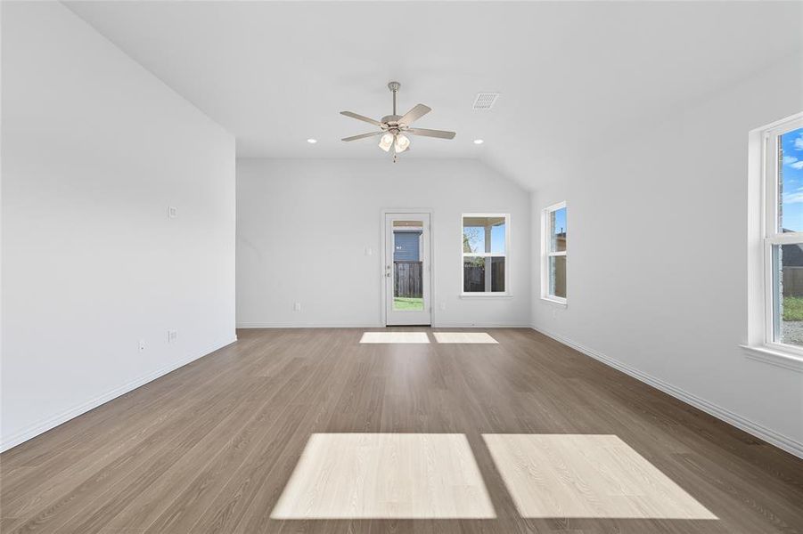 Unfurnished living room featuring wood finished floors, recessed lighting, lofted ceiling, and a ceiling fan Unfurnished living room featuring wood finished floors, recessed lighting, lofted ceiling, and a ceiling fan