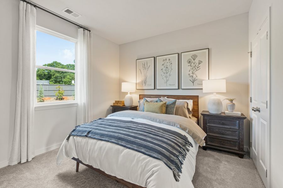 A bedroom with a bed and a window.