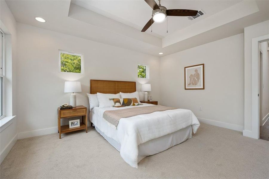 Primary bedroom with heightened tray ceilings