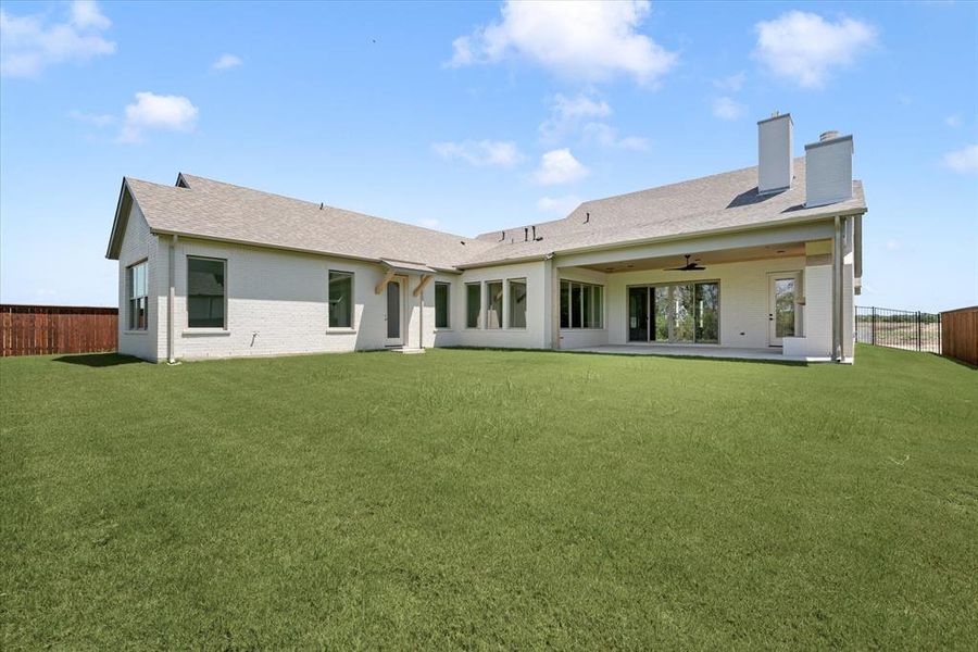 Rear view of property with a yard and a patio