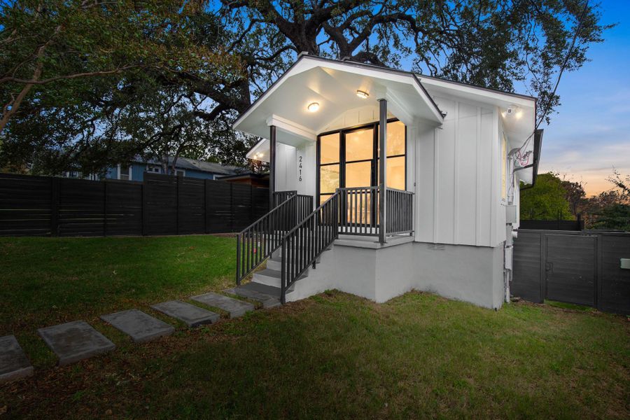 View of front of house with board and batten siding and a gate