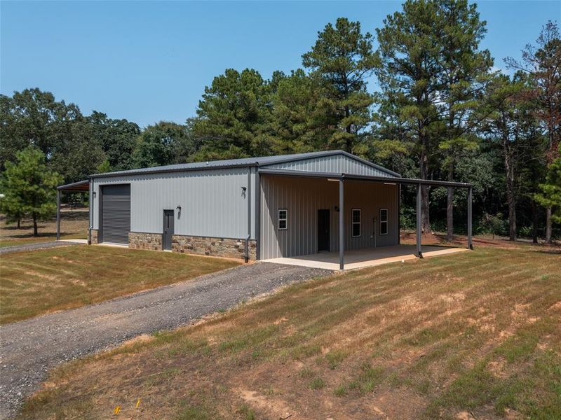 View of pole building with a yard