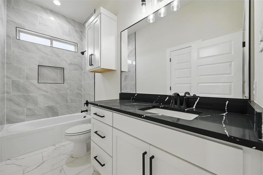 Bathroom featuring toilet, shower / bathtub combination, vanity, marble look tile flooring, and recessed lighting Bathroom featuring toilet, shower / bathtub combination, vanity, marble look tile flooring, and recessed lighting