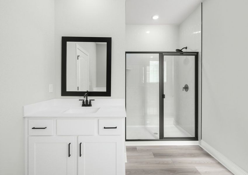 The master bathroom features a large walk-in shower and additional vanity