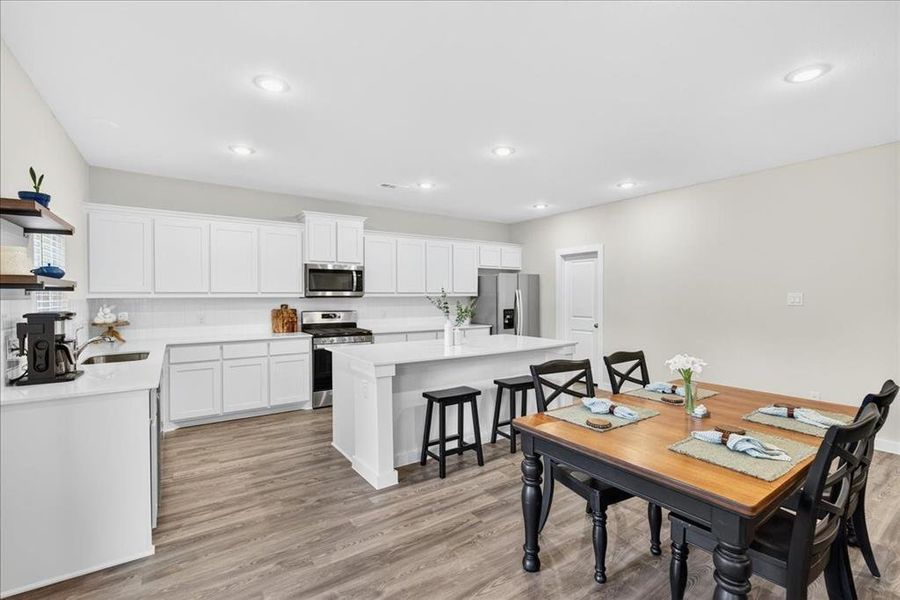 Dining space with luxury vinyl flooring, plenty of natural light, and recessed lighting Dining space with luxury vinyl flooring, plenty of natural light, and recessed lighting
