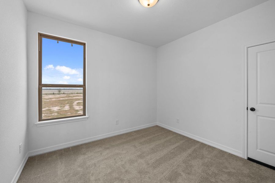 This secondary bedroom offers a quiet retreat with clean lines and natural warmth.