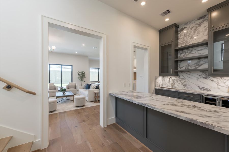 Positioned between gathering spaces, the bar becomes both anchor and extension designed for effortless entertaining and everyday convenience.