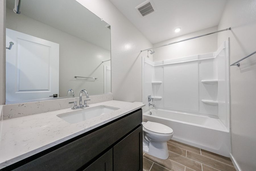 A bathroom with a tub sink and toilet. A bathroom with a tub sink and toilet.