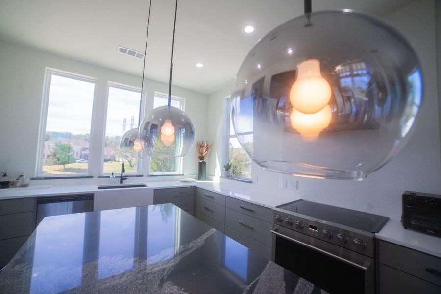 Start your mornings with a kitchen bathed in natural light, where a large window over the sink serves as a frame for the outdoors. This bright, airy focal point creates a cheerful atmosphere for meal prep and offers a peaceful view while you go about your daily routine.