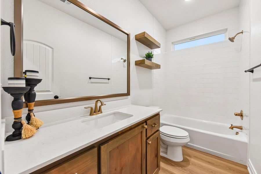 A well-lit bathroom showcases a pristine white bathtub and a contemporary vanity with a gleaming countertop. A well-lit bathroom showcases a pristine white bathtub and a contemporary vanity with a gleaming countertop.