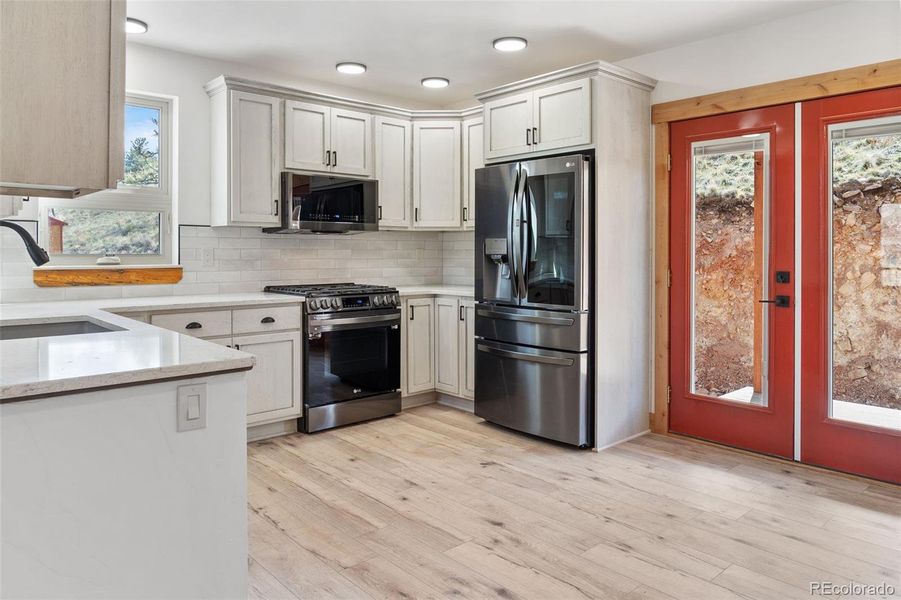 Double doors lead from the Kitchen to the back covered Trex deck