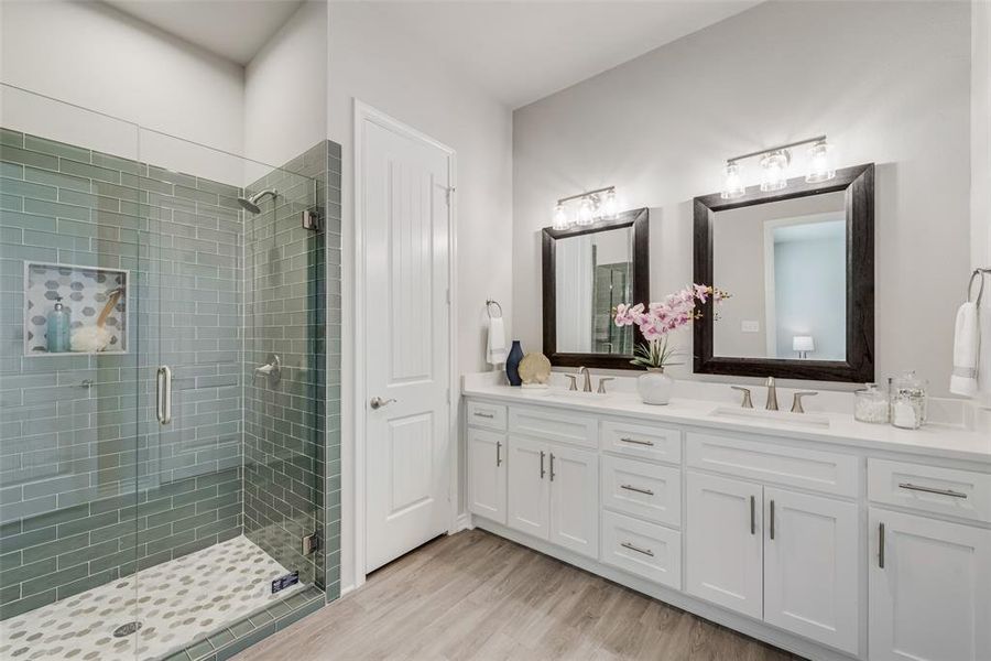 Bathroom with vanity, an enclosed shower, and wood-type flooring